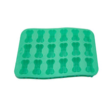 A bright green silicone mold tray with 16 bone-shaped cavities, displayed on a white sheet of paper.